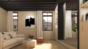 Un salon moderne avec un canapé, une table basse et un tableau accroché au mur.