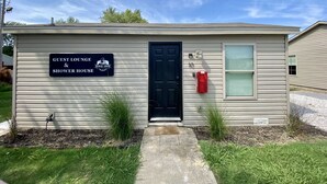 A small building with a sign indicating it is a guest lounge and shower house. - The Bike Inn #16, White River Cabin (Bentonville)
