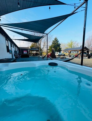 Un área de hidromasaje con un toldo, un tobogán y una piscina.