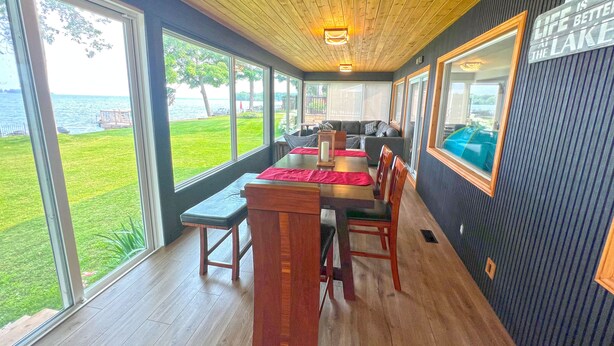 A dining area with a view of the lake, wooden ceiling, and a sign on the wall.
