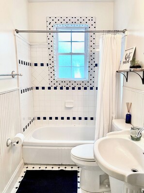 Un baño con bañera, inodoro y lavamanos.