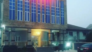 A hotel with a prominent 'Fibbs Hotel' sign, a covered entrance, and a parking area. - Fibis Hotel (Lekki)