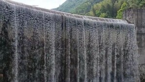 A large dam with water cascading down its side, surrounded by a forested area. - Jixi Huihanggudao Cuizhu Mountain Villa (Jixi)