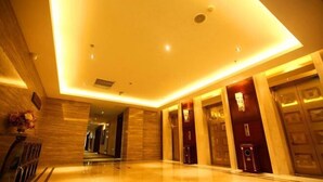 A hotel lobby with a polished marble floor, recessed lighting, and wooden paneling. - Yuchenyuan Hotel (Shuozhou)