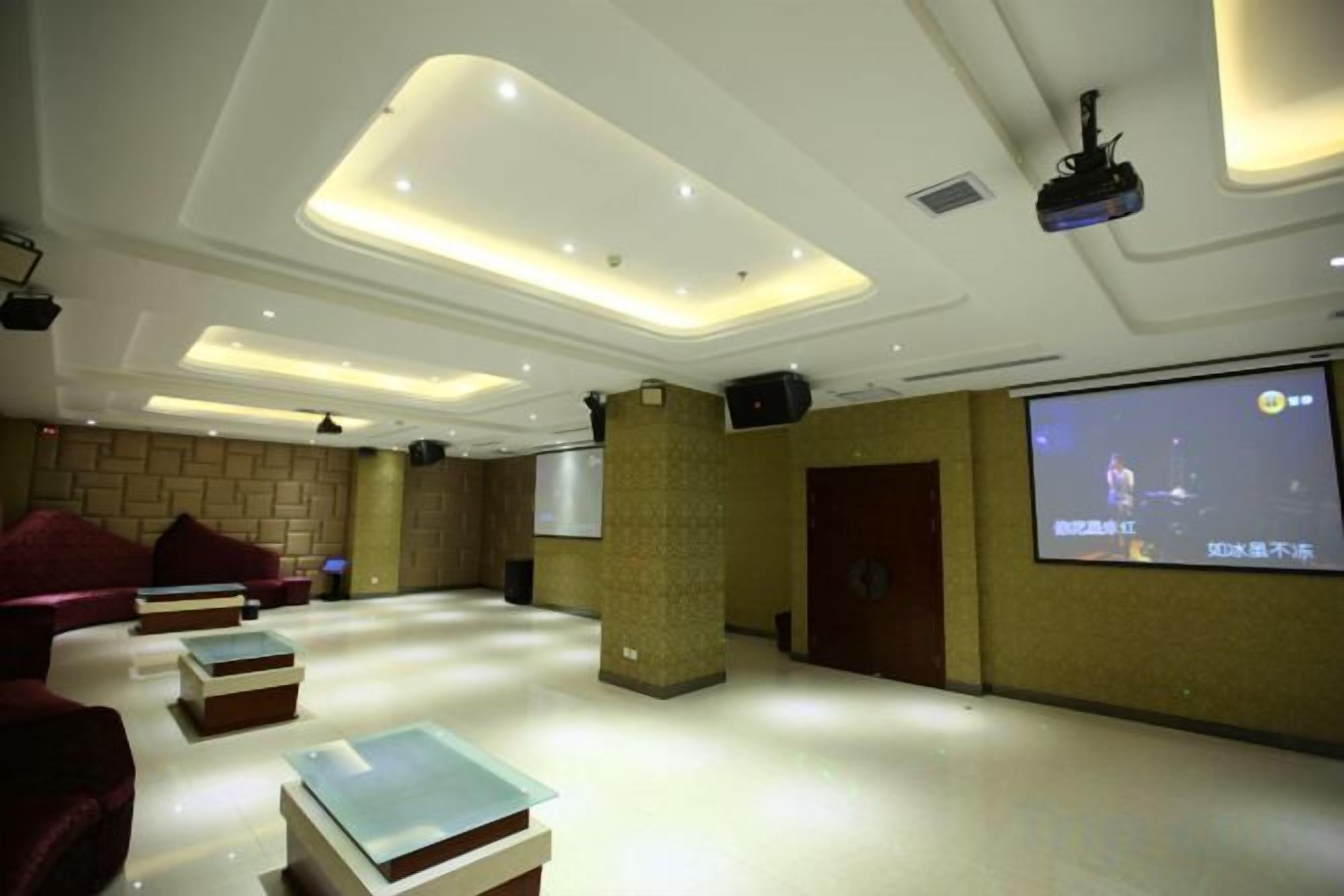 Una habitación moderna con televisión de pantalla plana, asientos cómodos y un proyector.