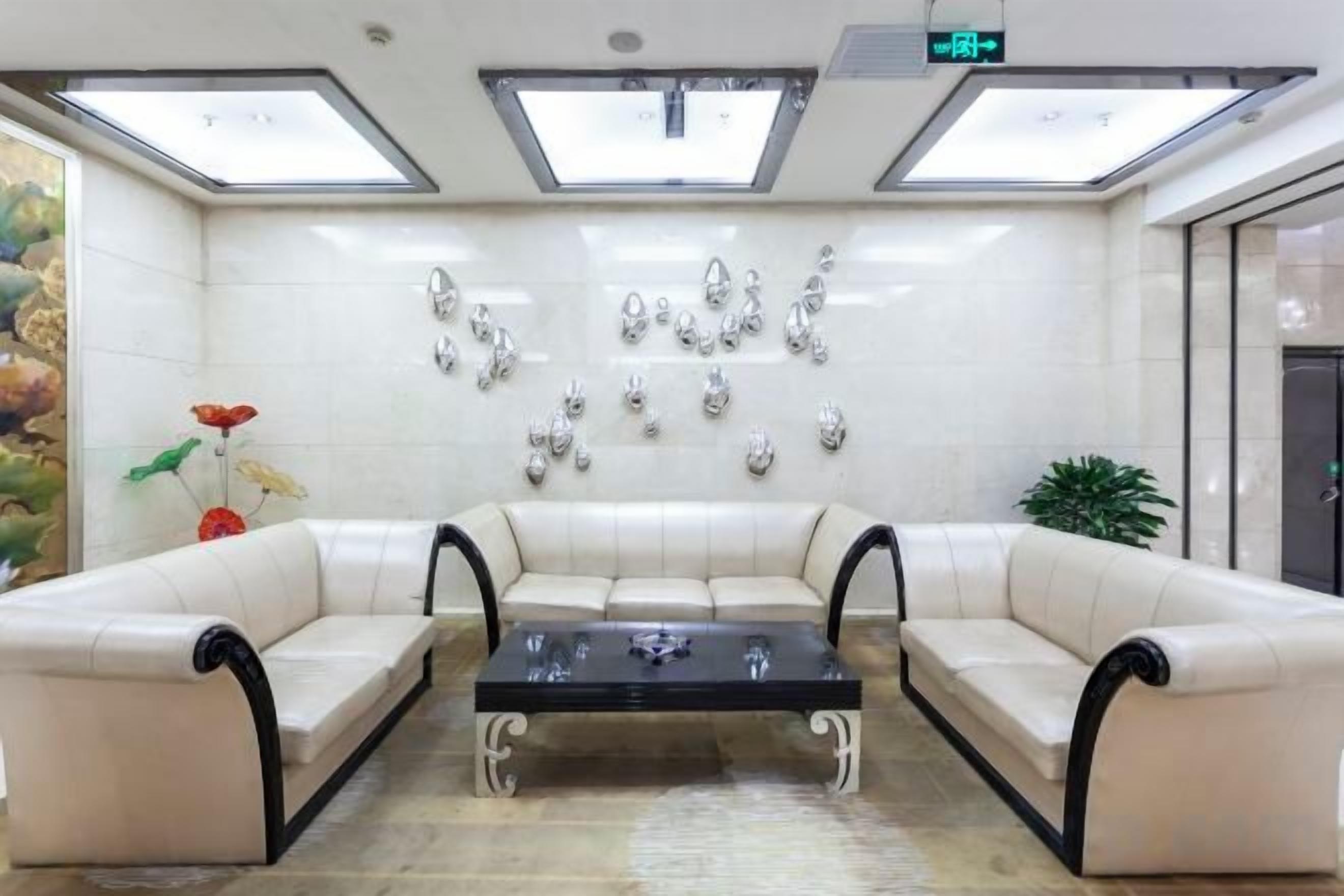 A lobby with a sectional sofa, a coffee table, and wall-mounted decorative items.