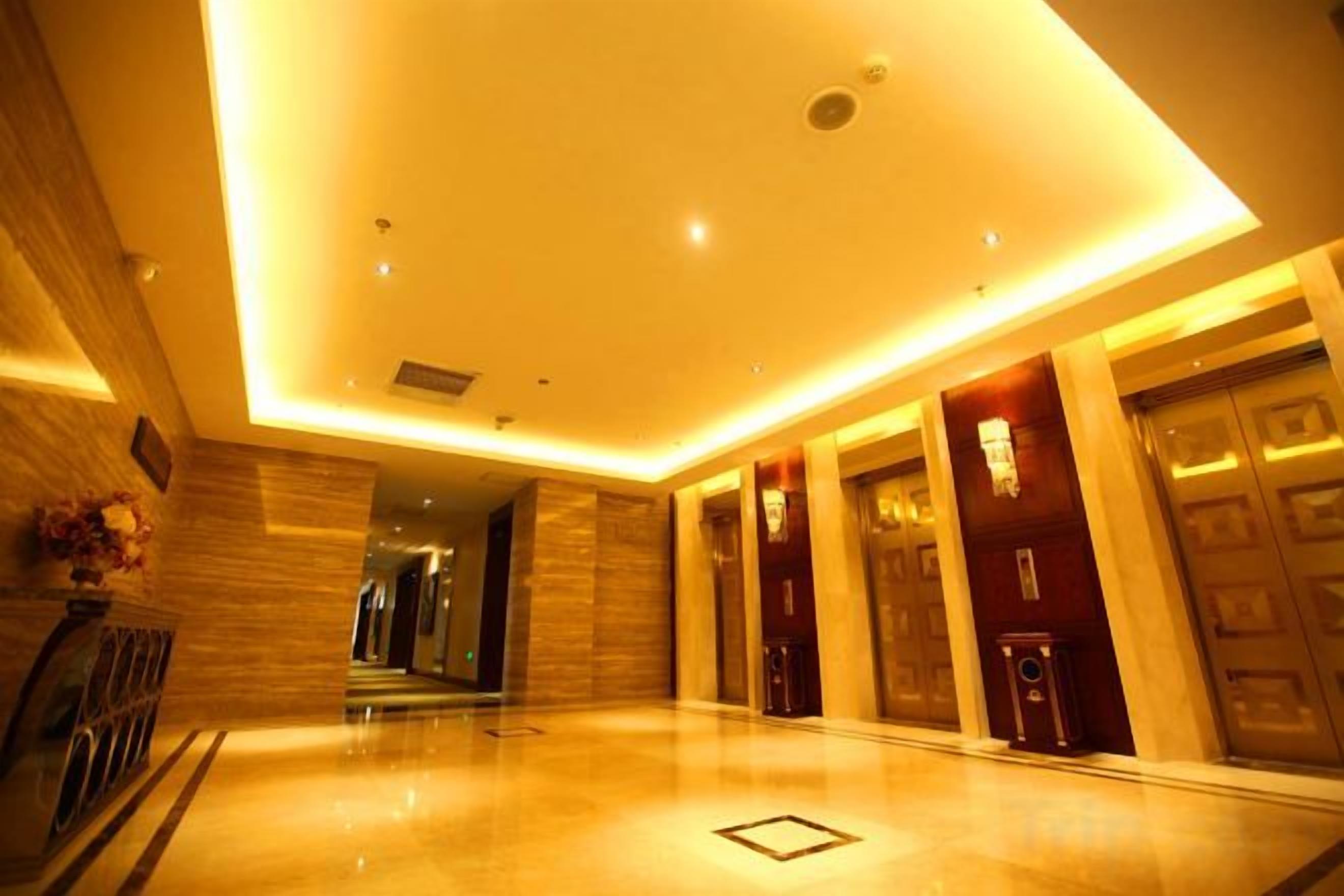 Rebedor d'hotel amb un sòl polit, una taula de recepció i una escala que condueix a un nivell superior.