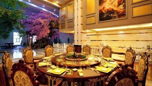 A formal dining area with ornate chairs and a round table set for a meal. - Royal Hotel (Xiaoyi)