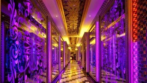 A hallway with ornate wall decorations and a checkered floor. - Royal Hotel (Xiaoyi)