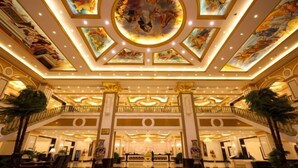 A grand lobby with a high ceiling, ornate columns, and a central chandelier. - Royal Hotel (Xiaoyi)