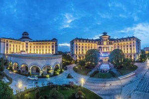 A large, circular building with a central courtyard, surrounded by smaller structures. - Shanghai Pudong Lingang Kaiyuan Hotel (Shanghai)