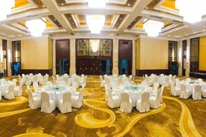 A large conference room with round tables and chairs, a patterned carpet, and a high ceiling with recessed lighting. - Shanghai Pudong Lingang Kaiyuan Hotel (Shanghai)