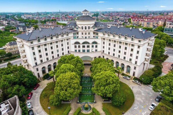 A large, historic building with a symmetrical facade, central courtyard, and surrounding greenery. - Shanghai Pudong Lingang Kaiyuan Hotel (Shanghai)