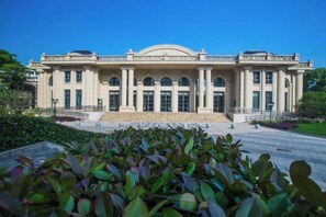 A large, classical building with a symmetrical facade, multiple columns, and a central entrance. - Shanghai Pudong Lingang Kaiyuan Hotel (Shanghai)