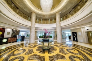 A spacious lobby with a central fountain, high ceilings, and a grand chandelier. - Shanghai Pudong Lingang Kaiyuan Hotel (Shanghai)