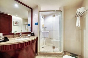 A modern bathroom with a glass-enclosed shower, a vanity with two sinks, and a large mirror. - Shanghai Pudong Lingang Kaiyuan Hotel (Shanghai)