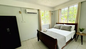 Una camera da letto con un letto, un armadio e una finestra con tende.