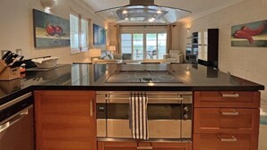 Una cocina moderna con una isla central, electrodomésticos de acero inoxidable y obras de arte en las paredes.
