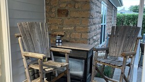 A patio with two wooden Adirondack chairs and a stone fireplace. - My Blue Haven is a Walkers Paradise 5 min to the Monument and 15 min to Downtown (Rapid City)