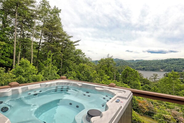 A hot tub with a view of a lake and forest.