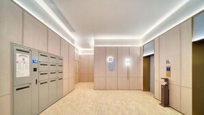 A hallway with lockers, a wall-mounted elevator control panel, and a trash bin. - HanTing Hotel (Cixi Guanhaiwei) (Cixi)
