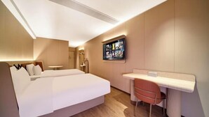 Une chambre d’hôtel moderne, dotée d’un grand lit, d’un bureau et d’une chaise.