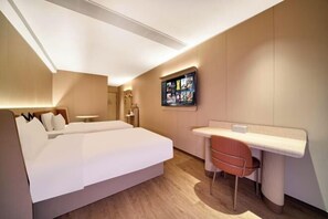 Une chambre d’hôtel moderne, dotée d’un grand lit, d’un bureau et d’une chaise.