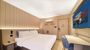Une chambre d’hôtel équipée d’un lit, d’une table de chevet, d’une chaise et d’un bureau avec un ordinateur.