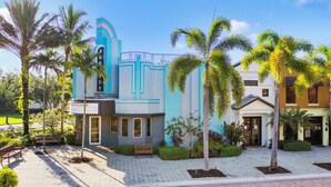 Un immeuble à la façade bleue et blanche, doté d’un balcon et d’une enseigne indiquant « Centre d’affaires ».