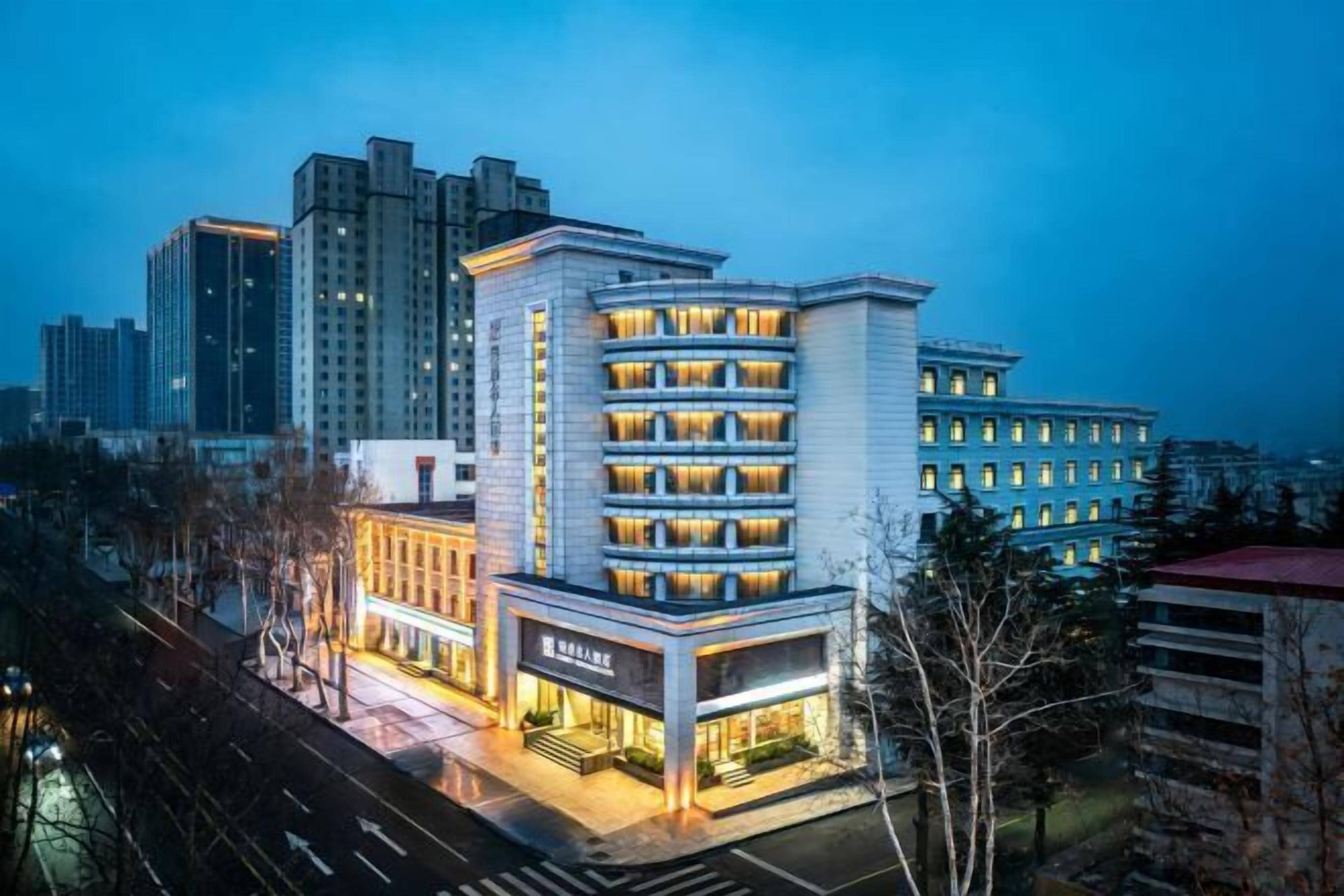 A multi-story hotel with a modern design, featuring a prominent entrance and a visible restaurant on the ground floor.