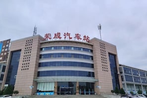 A multi-story building with a prominent sign at the top. - Rongcheng Celebrity Hotel (Rongcheng High Speed Rail Station Shop) (Rongcheng)