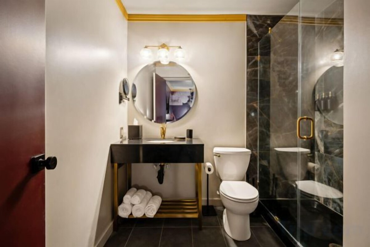 Un baño con inodoro, lavamanos y espejo.