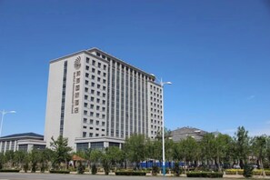 A multi-story hotel with a modern design, featuring a prominent logo on the facade. - Bohai International Hotel (Huanghua)