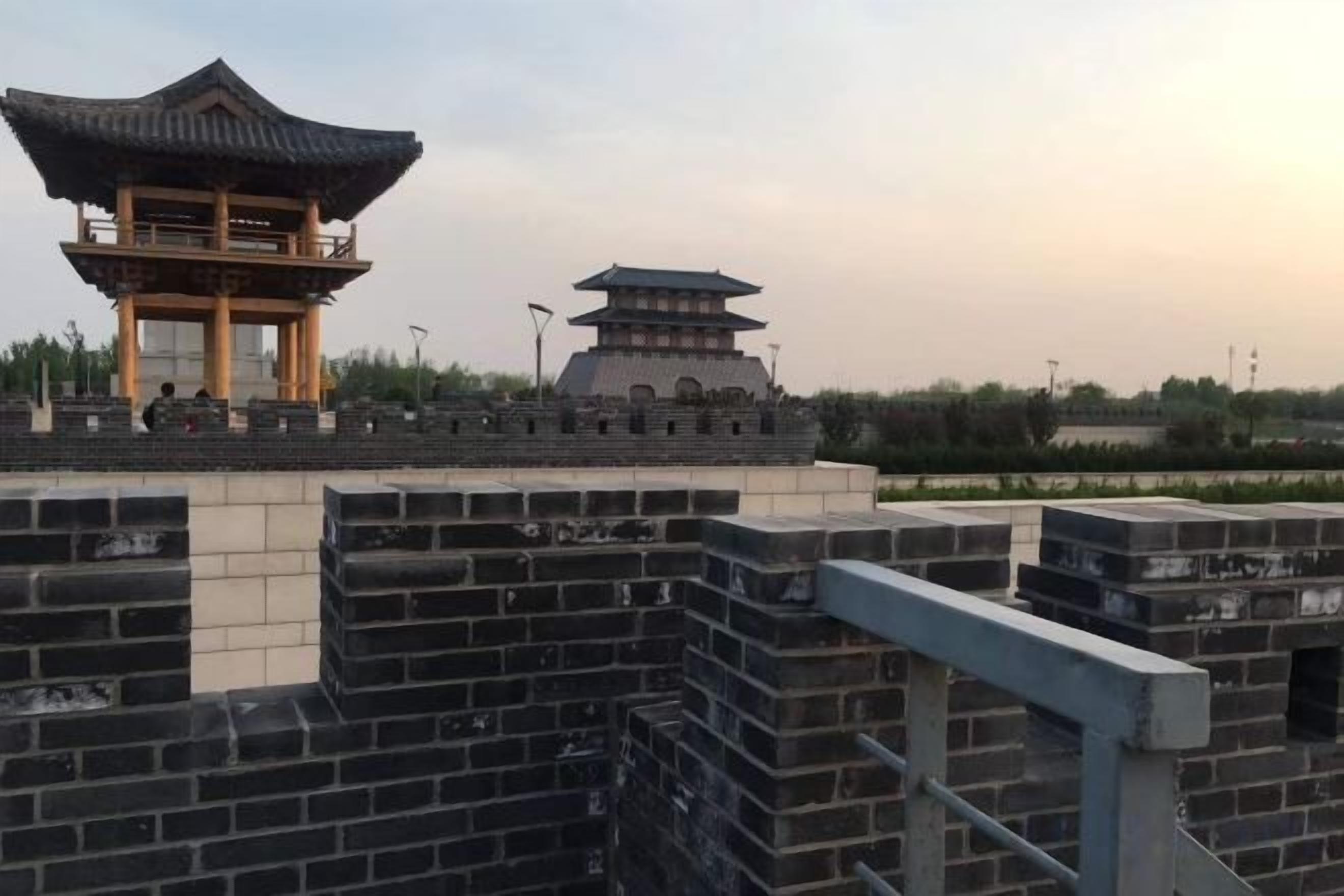 A traditional Chinese architectural structure with a multi-tiered pagoda and a pavilion on a brick platform.