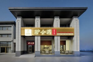 A modern building with a prominent sign for a restaurant. - Bohai International Hotel (Huanghua)