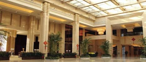 A spacious lobby with high ceilings, large columns, and a polished floor.