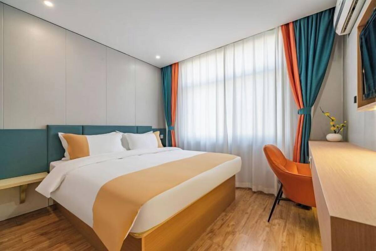 Una habitación de hotel con una cama, un escritorio y una silla.