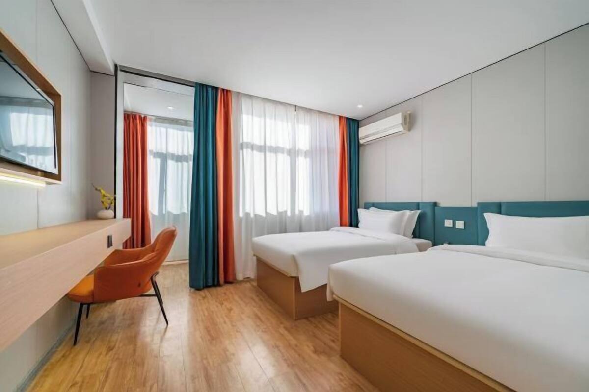 Una habitación de hotel con dos camas, un escritorio y una silla.