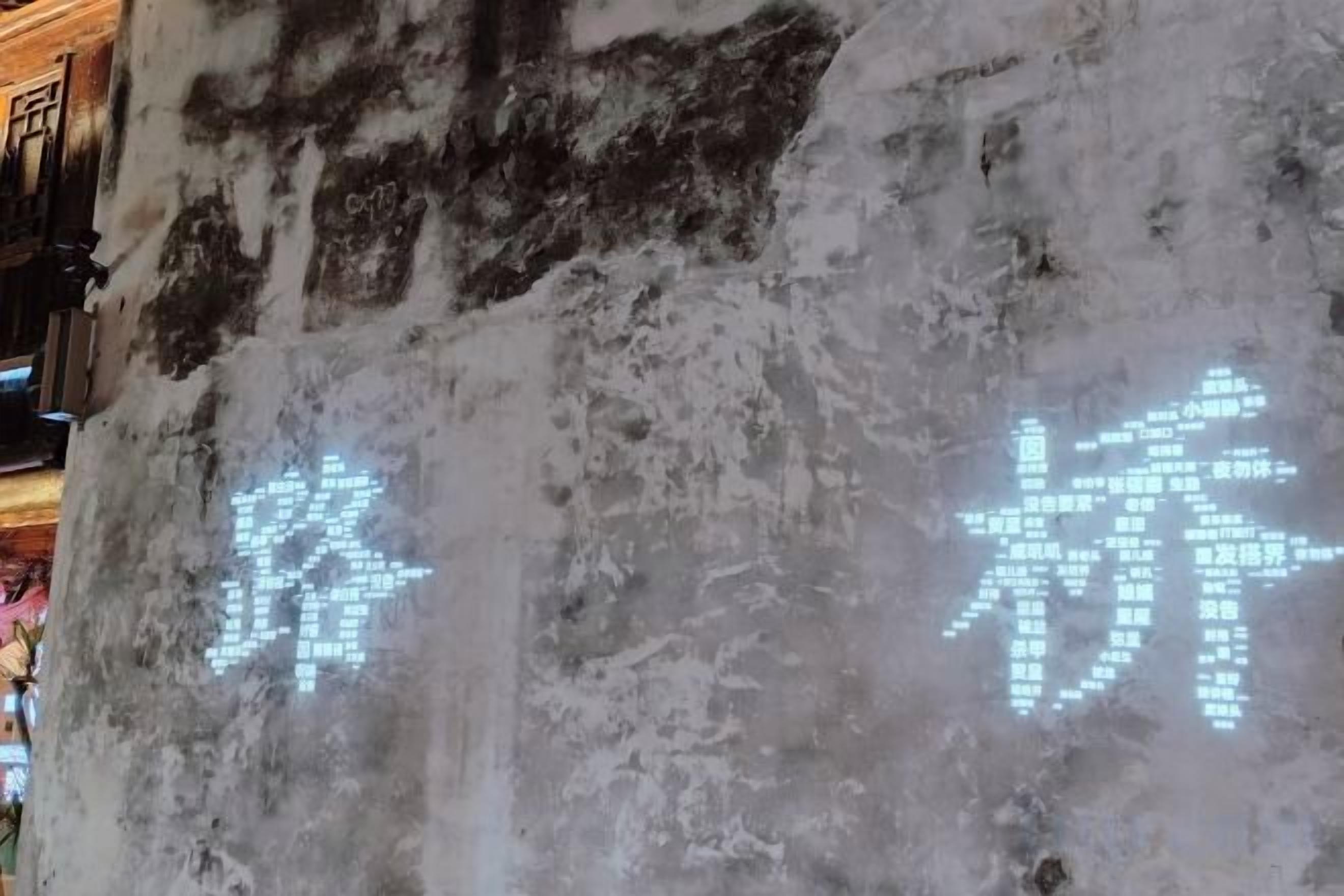 A textured wall with illuminated characters.