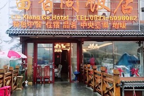 A traditional Chinese restaurant with a tiled roof, wooden furniture, and a signboard with contact information. - Liuxiangge Hotel (Emeishan City)