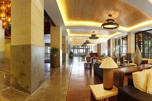A spacious lobby with high ceilings, modern lighting fixtures, and comfortable seating areas.