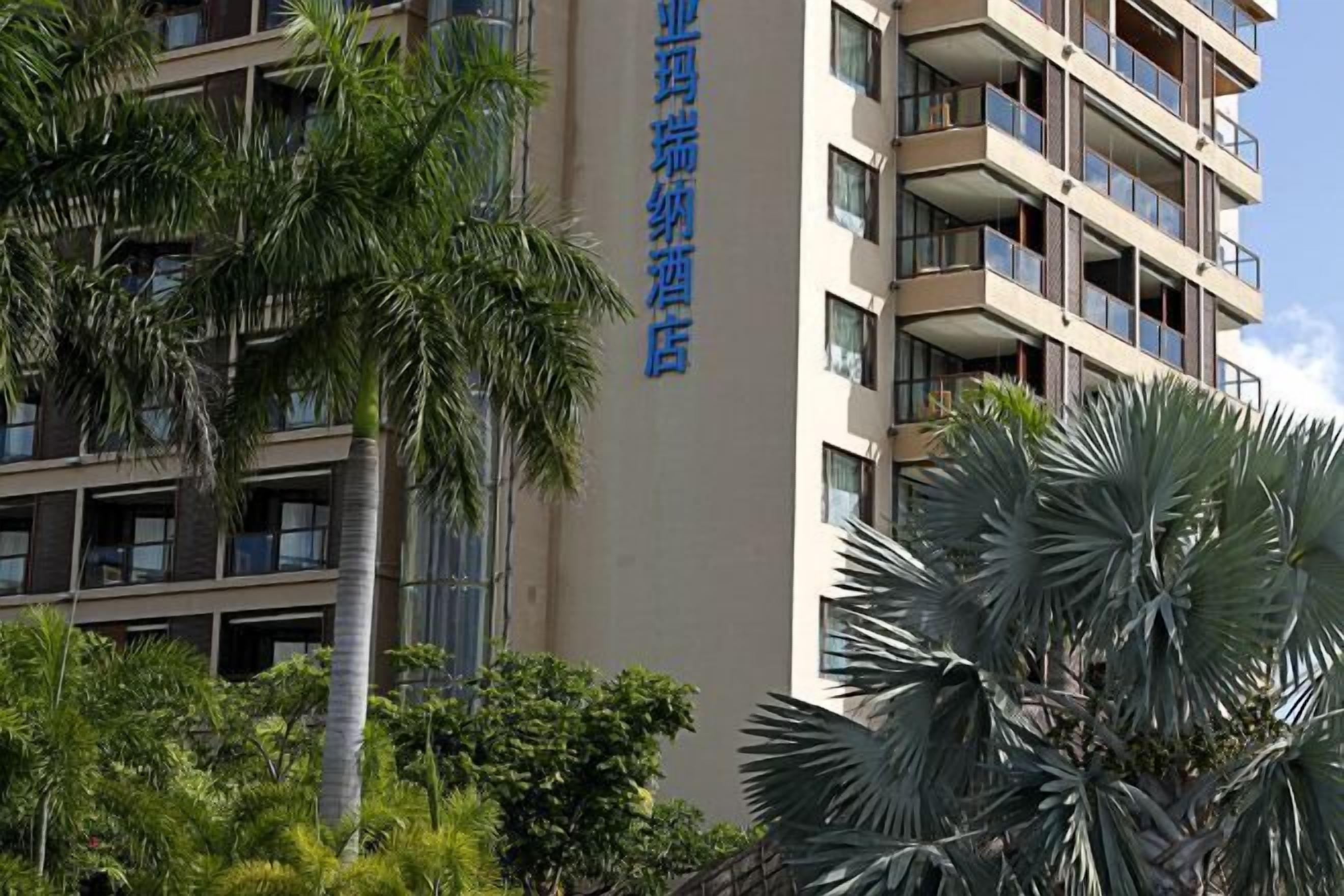Un immeuble d’hôtel à plusieurs étages, doté de balcons et d’une enseigne en caractères chinois.