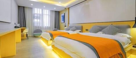 A hotel room with two beds, a desk, and a chair.