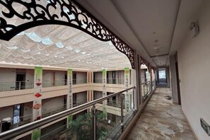 A corridor with a glass railing, decorative ceiling, and multiple floors with balconies. - Jianlang Holiday Hot Spring Hotel (Shilin)