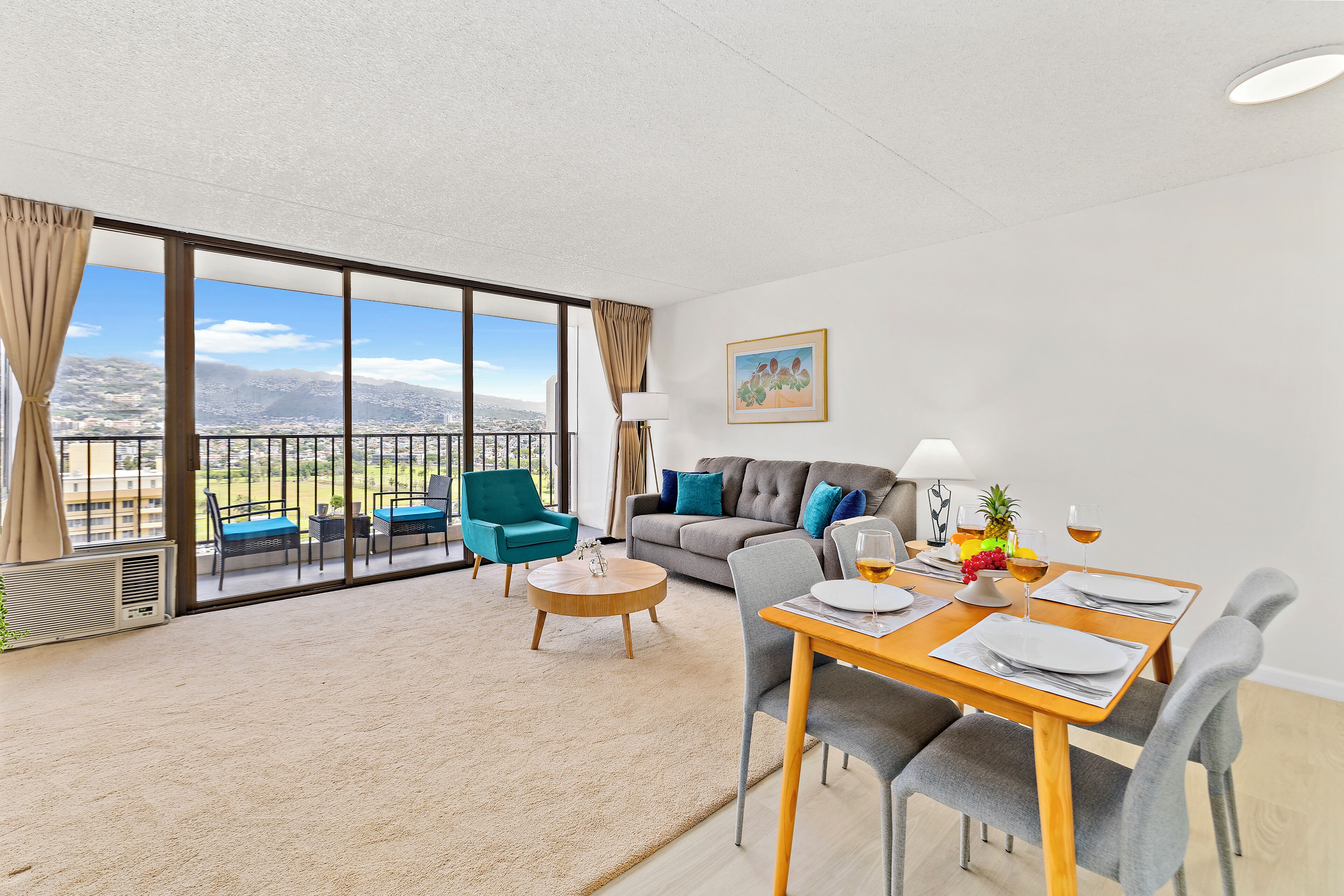 A modern living room with a balcony, a dining area, and a sofa set.