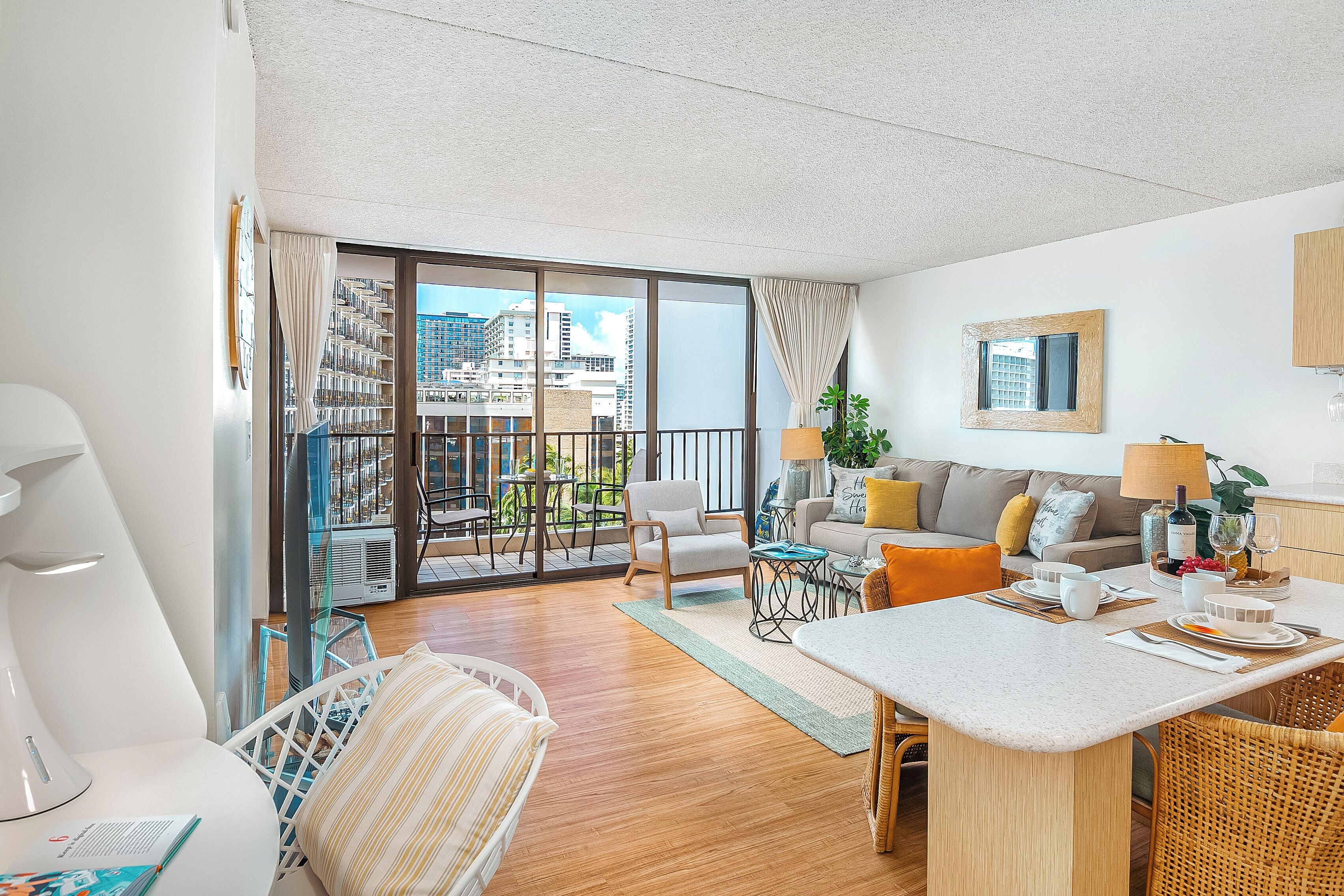 A modern living room with a balcony, a dining area, and a kitchen.