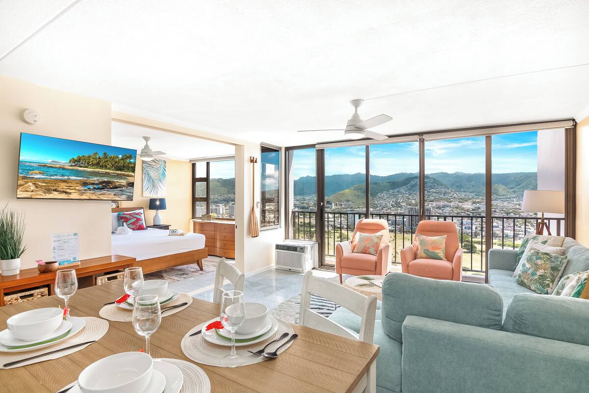 Une chambre d’hôtel moderne dotée d’un balcon, d’un lit, d’un coin repas et d’un canapé.
