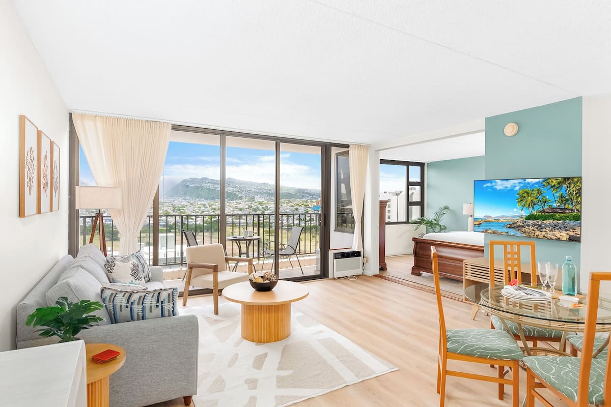 Un salon moderne avec un canapé, une table basse ronde et un coin repas avec des chaises.