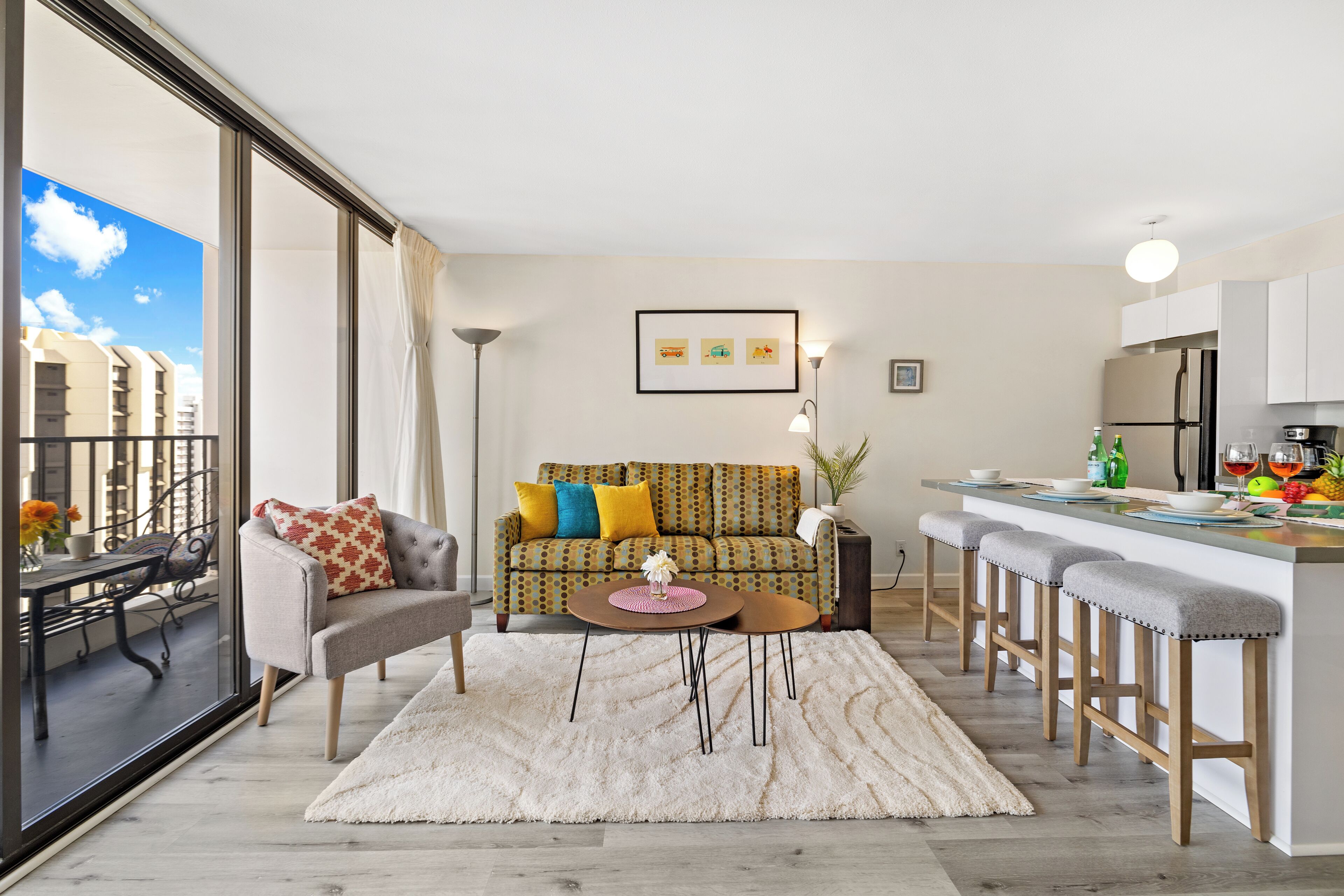 Een modern appartement met een zithoek, keuken en grote ramen.
