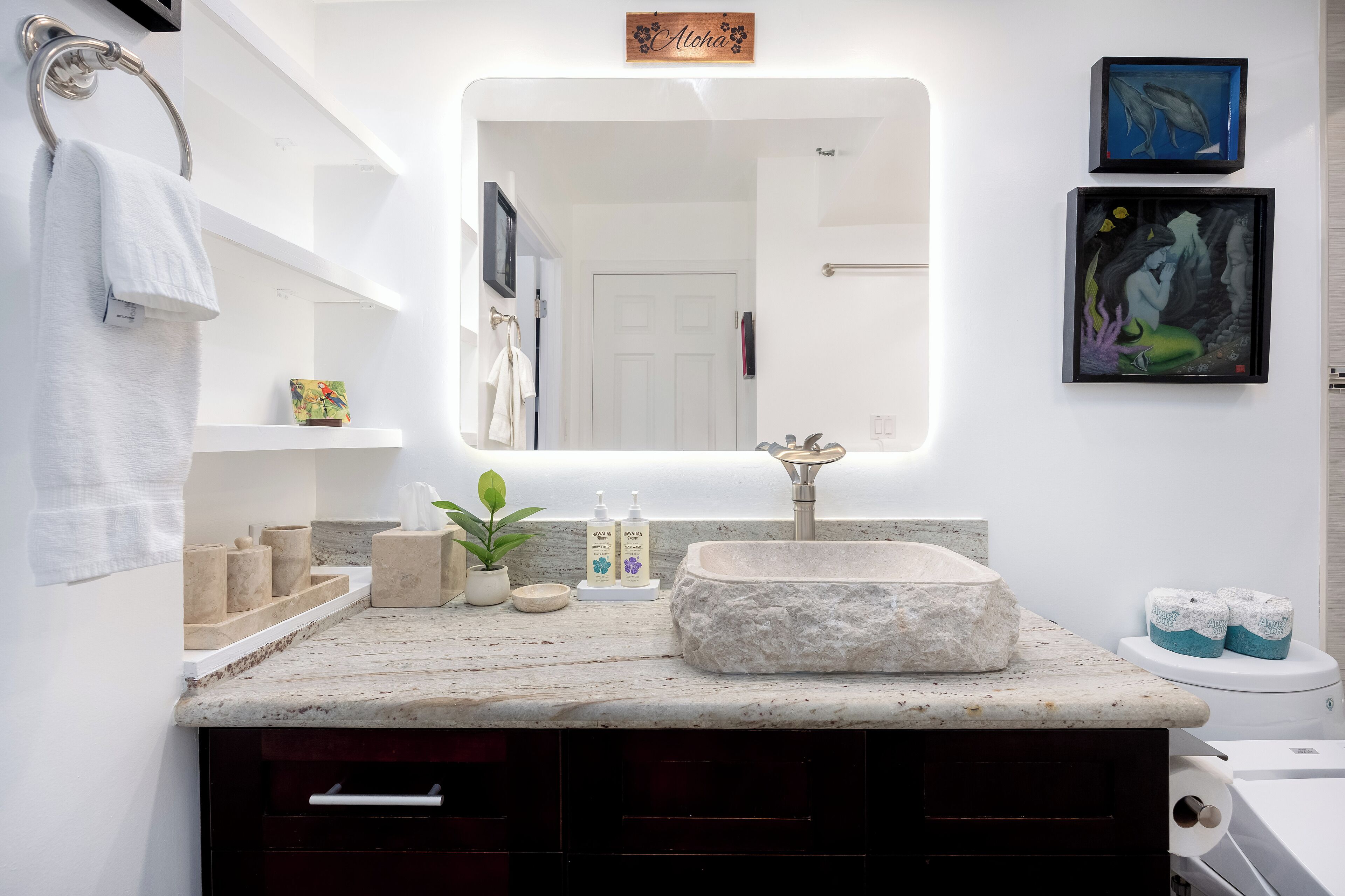 A bathroom with a freestanding sink, a mirror, and a towel rack.
